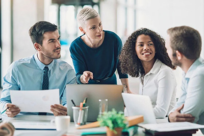 商務會議，兩男兩女；金發女人正在電腦屏幕上討論一些事情